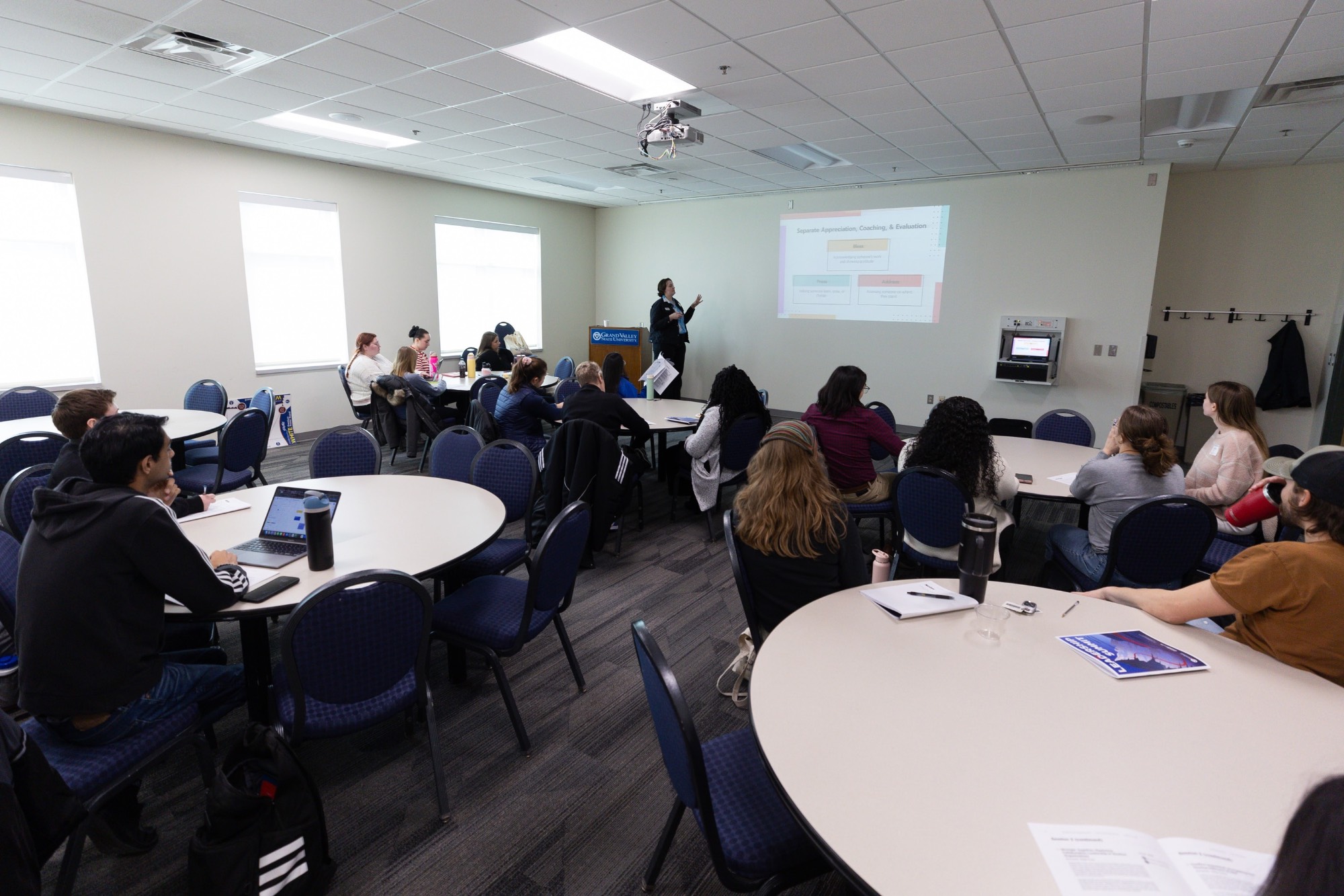 Room full of students watching Leadership Summit presentation